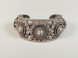 a close up of a silver bracelet with pearls on it