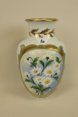 a white vase with flowers painted on it on a table