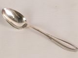a silver spoon with a spoon handle on a white surface