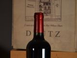 a bottle of wine sitting on a table next to a box of wine