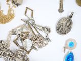 a lot of silver jewelry on a white surface
