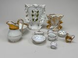 a white and gold tea set on a white table
