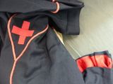 a black jacket with a red cross on the front and a red cross on the back