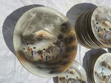 many plates with asian paintings on them sitting on a table