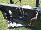 an image of a skid steer attachment in the grass