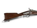 un vieux fusil avec un canon en bois et des garnitures métalliques