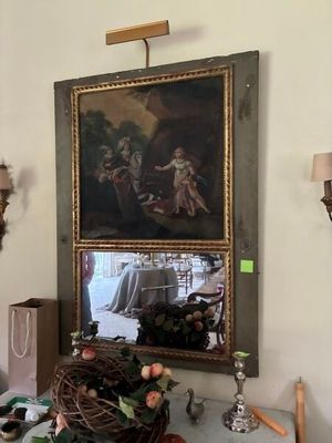 un tableau accroché au mur au-dessus d'une table sur laquelle se trouve une corbeille de fruits