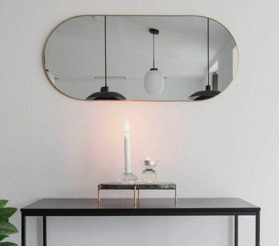 a table with a candle and a mirror on it