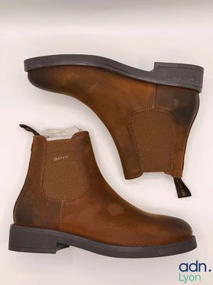 un gros plan sur une paire de bottes marron sur fond blanc