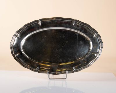 a silver platter on a stand on a table