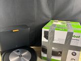 the box of the robot vacuum is next to it ' s packaging