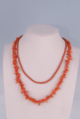 un collier de perles de corail orange sur un mannequin