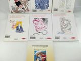 a set of six anime books on a white surface