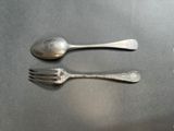two spoons and a fork sitting on a table