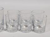six glasses sitting next to each other on a table