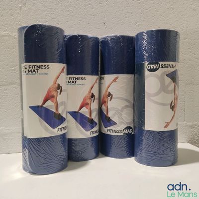 trois rouleaux de tapis de yoga bleus posés sur une table blanche