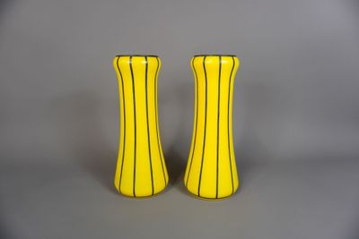 deux vases jaunes posés l'un à côté de l'autre sur une table