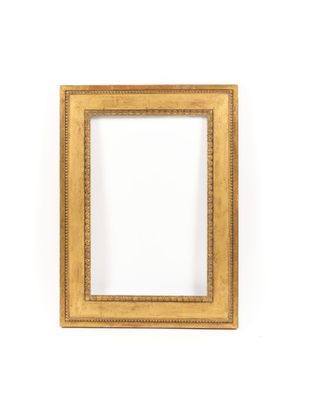 a gold picture frame on a white wall with a white background