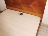 a bed that has a wooden headboard on top of it