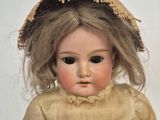 a doll that is wearing a hat and a dress