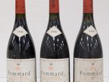 three bottles of red wine are lined up on a white surface