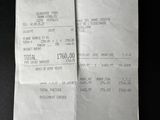 a close up of a receipt on a table with a black background