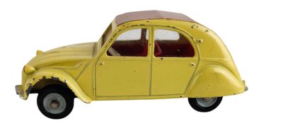 une petite voiture jaune posée sur une surface blanche, à côté d'un mur blanc