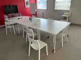 a white table and chairs in a room with a red wall