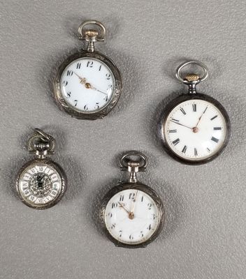 Quatre types différents de montres de poche sont exposés sur une table
