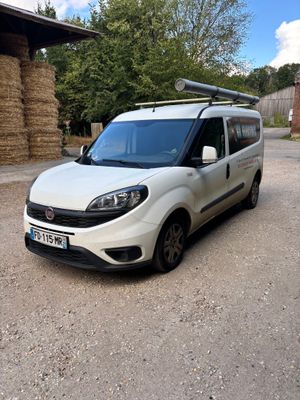 the white van is parked in front of a hay bale