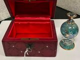 une petite boîte rouge avec un flacon de parfum à côté