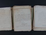 three old papers with writing on them sitting on top of a table