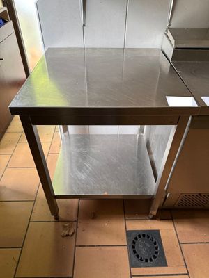 une table en acier inoxydable au milieu d'un sol carrelé