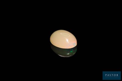 a white egg sitting on top of a black table