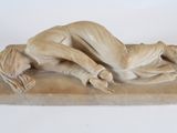 statue of a man and woman laying down on a marble base