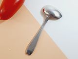 a spoon and a hot dog on a table