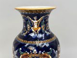 a blue and gold vase sitting on a table