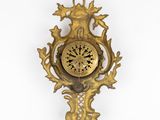 a gold clock on the wall with a white background