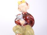 a figurine of a boy sitting on a rock