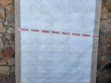 a close up of a piece of paper taped to a stone wall