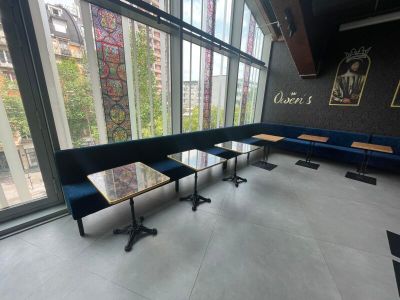 des tables et des bancs dans une pièce dotée de grandes fenêtres et offrant une vue sur la ville