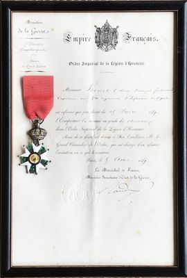 un vieux document orné d'un ruban rouge et d'une médaille