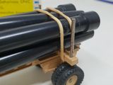 a toy truck that has a bunch of pipes on it