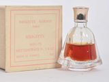 a small bottle of perfume sitting next to a box