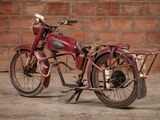 a red motorcycle that is parked in front of a brick wall