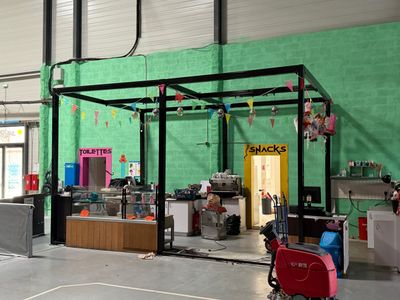 une pièce avec un mur vert et un chariot rouge à l'intérieur