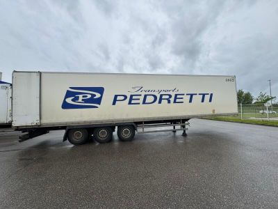 un semi-remorque blanc garé sur le bord de la route
