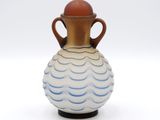 un vase bleu et blanc avec une anse marron sur un fond blanc