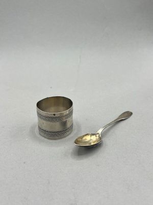 silver plated cup and spoon sitting on a white surface