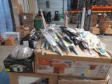 many different types of knives on a box in a warehouse